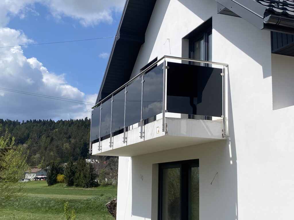 Nowoczesna barierka szklana z czarnego szkła dymionego na spigotach podłogowych i rotulach bocznych od producenta Insteelglass