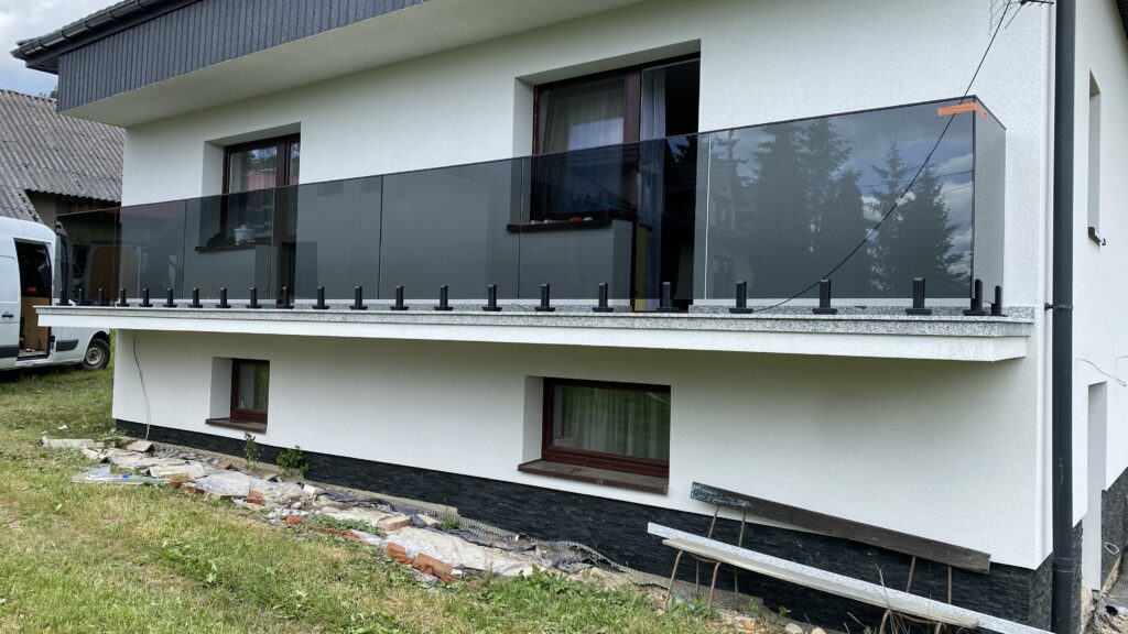 Nowoczesna barierka z ciemnego szkła na punktowych czarnych rotulach bocznych, styl modern loft dla apartamentów w Krakowie