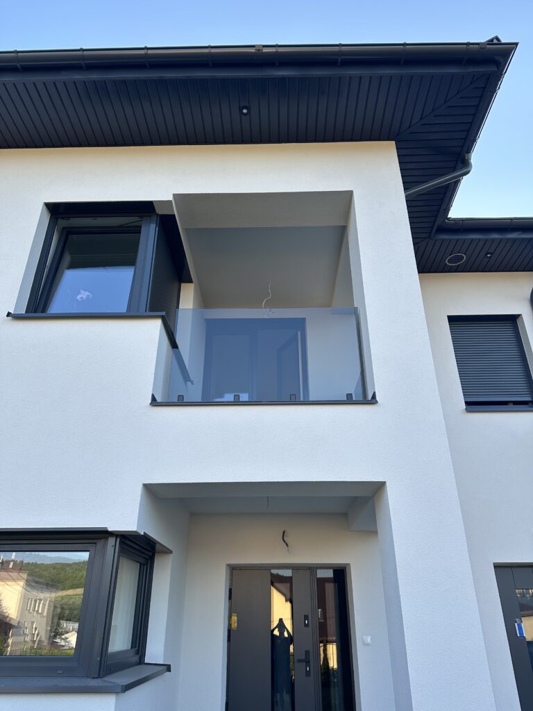Przyciemniana balustrada szklana na dolnych uchwytach spigot w kolorze czarny mat, nowoczesny design balkonu